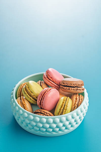 istock Different flavors of macarons. Colourful macaroons in bowl on blue background. 2237172269