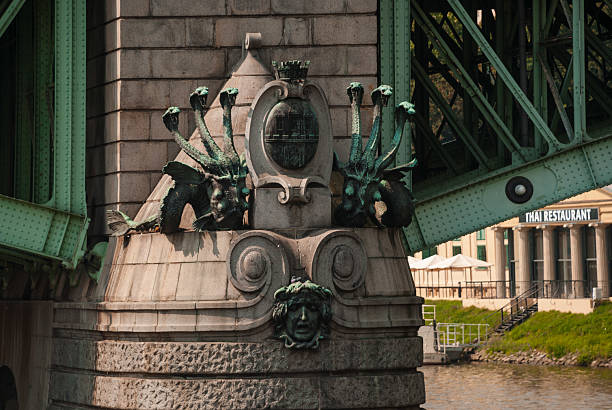 Prague, Czech - August 22, 2013 - Ornate sculptures and pillars on an intricate bridge with unique design elements.