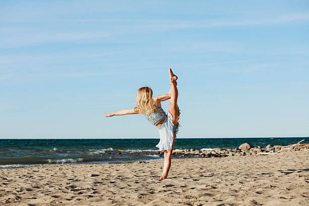A beautiful girl, 10 years old, dancing on the beach. Shot with a Canon 5D Mark IV.