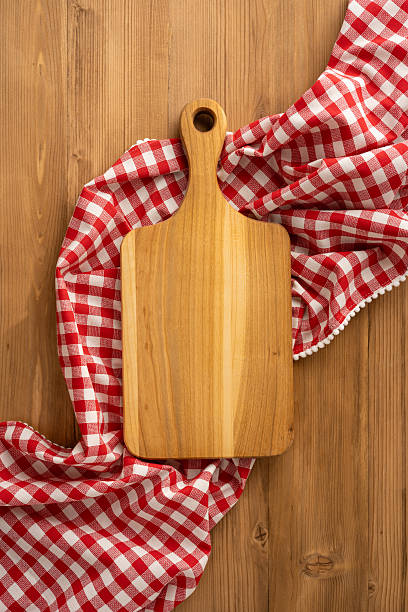istock Vertical view of wooden cutting board on a rustic table with red checkered cloth, evoking a cozy, inviting feeling for Thanksgiving day celebration highlighting culinary preparation and dining moments 2237187116