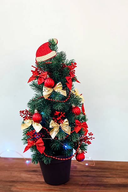 istock Small Christmas tree decorated with red ornaments and lights in a cozy indoor setting 2237187518