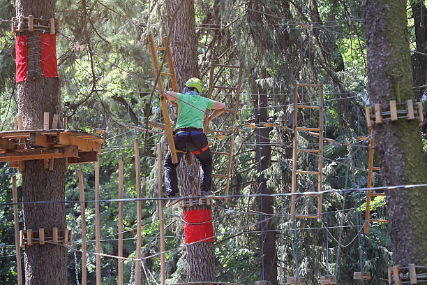 People in a helmet rope park active holidays in the forest. Extreme vacation