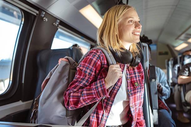 istock Happy traveler with backpack on a train, smiling and ready for a new journey 2237189167