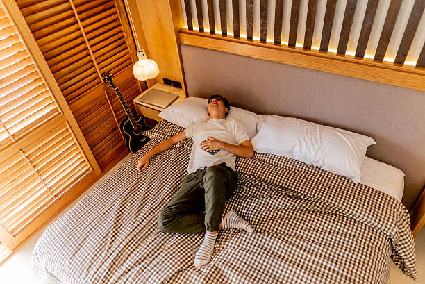 istock Teenage boy lying on bed at home 2237192595