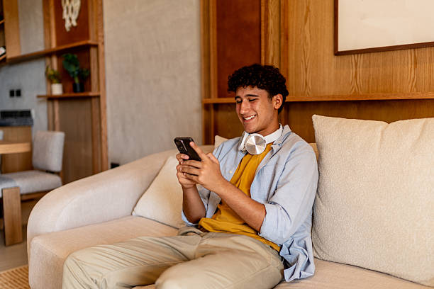 istock Teenage boy using mobile phone at home 2237192664