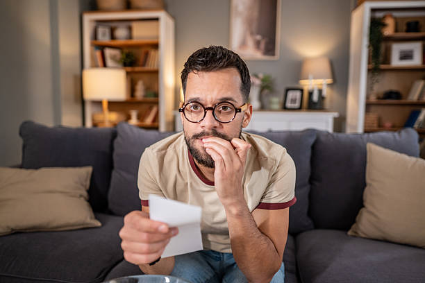 istock Man biting nails feeling anxious and stressed holding lottery ticket 2237202684