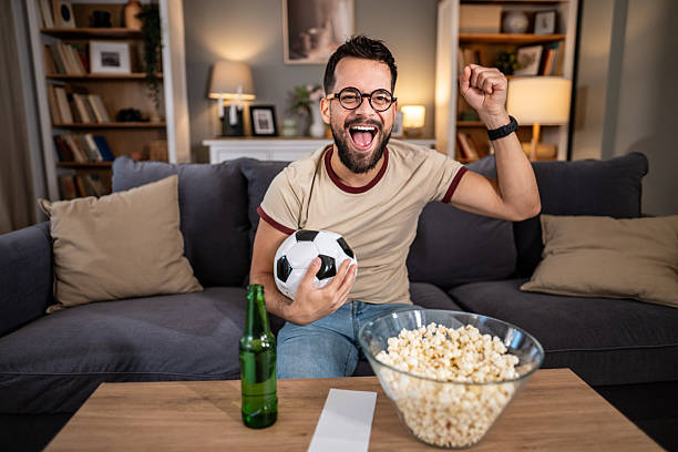 istock Excited man watching soccer on tv at home 2237202794