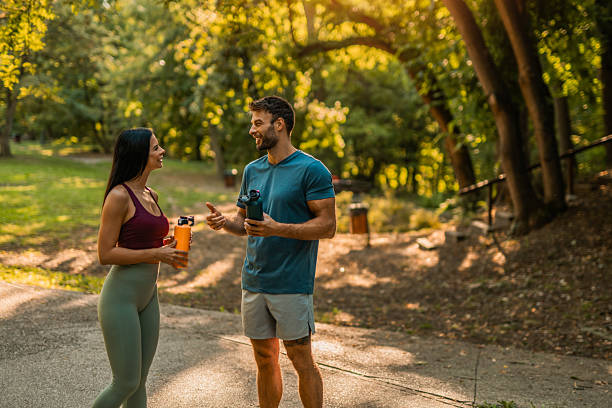 istock Happy athletic couple communicating while taking a break from running in the park. 2237205064