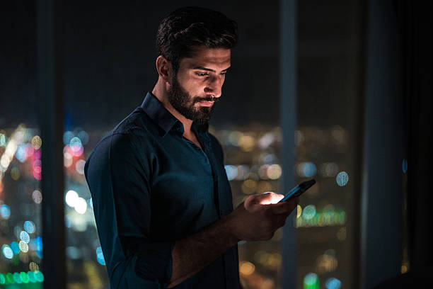 istock Thoughtful Arabic Man Using Smartphone in Modern Home with Riyadh View 2237212595