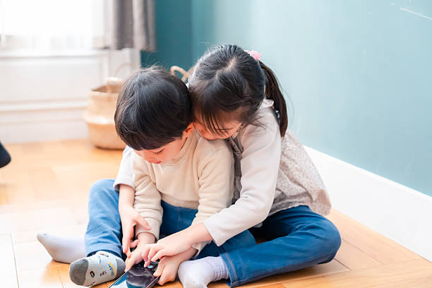 istock A small child fighting with a sibling for a phone 2237215814