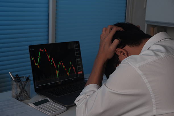 istock Sad businessman working at night, looking at laptop screen showing trading graph down, bitcoin, stock market. 2237217623