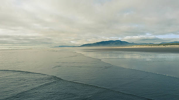 istock View northward along a sandy beach towards a distant dark ridge 2237220467