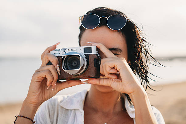 istock Woman using vintage camera on beach trip 2237222216