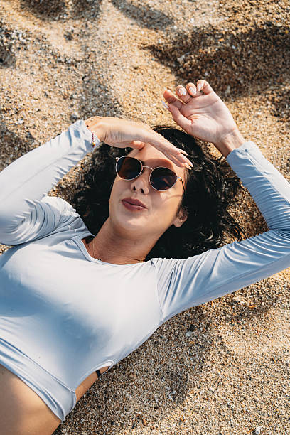 istock Woman relaxing on beach protecting face from sun 2237222226