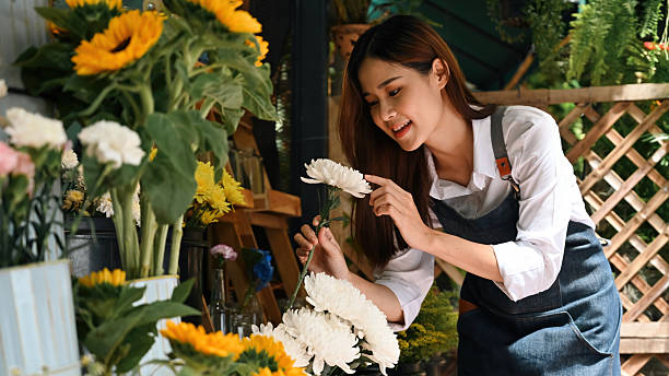 istock A Young florist arranging white flowers while smiling for display in a vibrant retail setting 2237232262