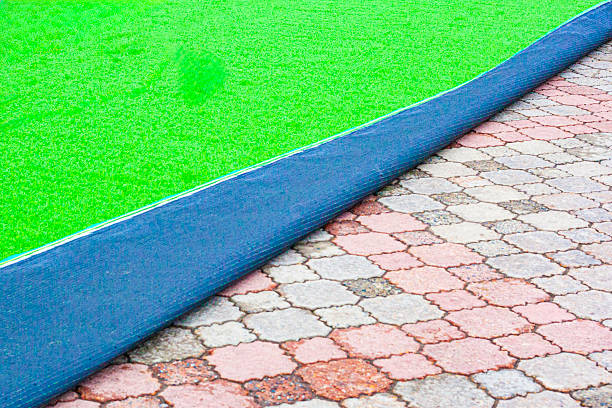 istock installation of green artificial grass on paving slabs using a hammer drill to avoid tearing off in strong winds and emergency situations 2237237054