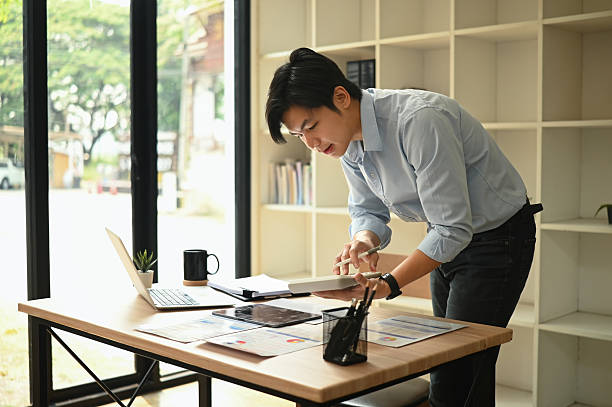 istock A Confident businessman standing at a desk reviewing financial reports and using a calculator to analyze business performance in a workspace 2237248974