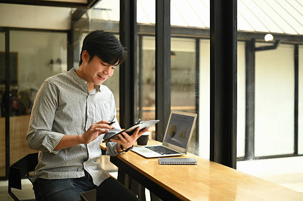 istock An Asian businessman using a tablet device for work in a modern workspace 2237249327