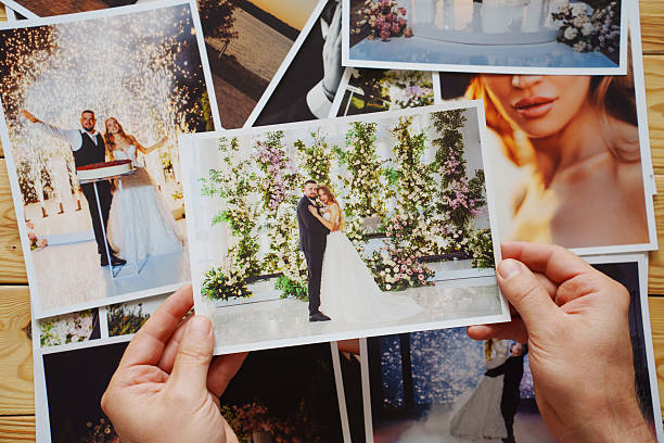 istock Men's hands put on the table and show wedding photos. 2237250303