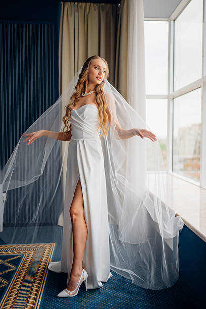 istock The bride standing by the window. simple beautiful elegant wedding dress 2237253092