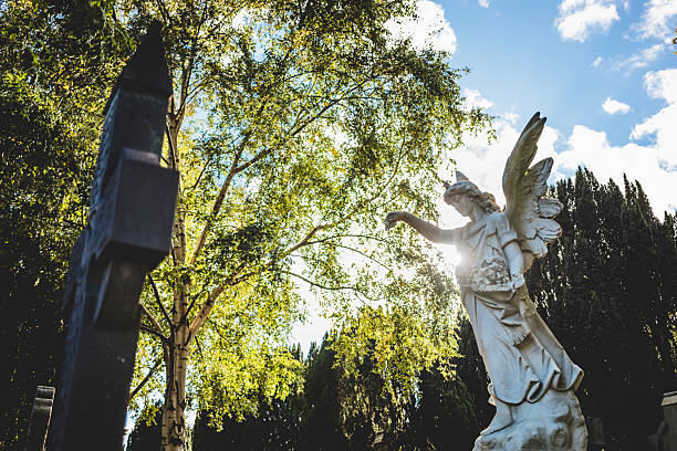 Dublin, Ireland - September 23, 2018: Angel statue surrounded by trees captures autumn light.