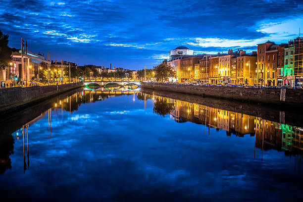 Dublin, Ireland - September 22, 2018: Evening views show colorful building reflections on the River Liffey under a twilight sky.