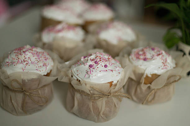 Sweet muffin dessert decorated with sprinkles and powdered sugar, alongside its healthier alternative a gluten-free, sugar-free version. Scene contrasts indulgence and mindful eating.