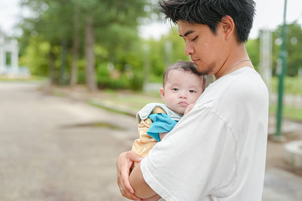 istock A man is holding a baby in his arms 2237261337