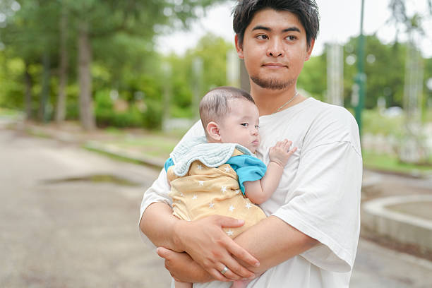istock A man is holding a baby in his arms 2237261439