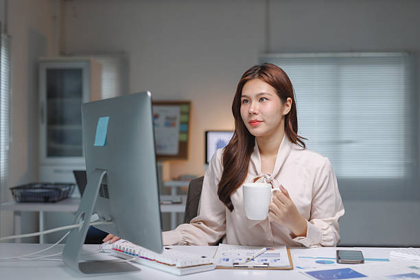 istock Asian businesswoman working late drinking coffee 2237262090