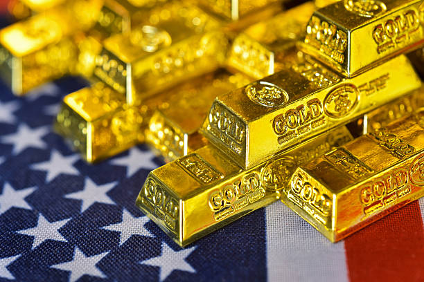 istock Stacking gold bars on US flag and golden light background. 2237265314
