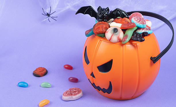 istock Various halloween sweets on pumpkin basket. Halloween 2237265702