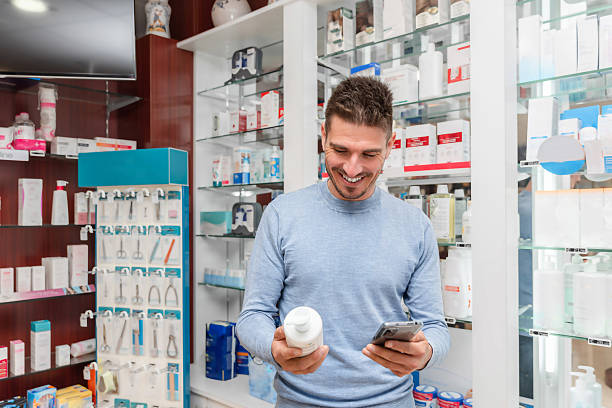 istock Smiling man using phone and checking medication information in a pharmacy store 2237268994