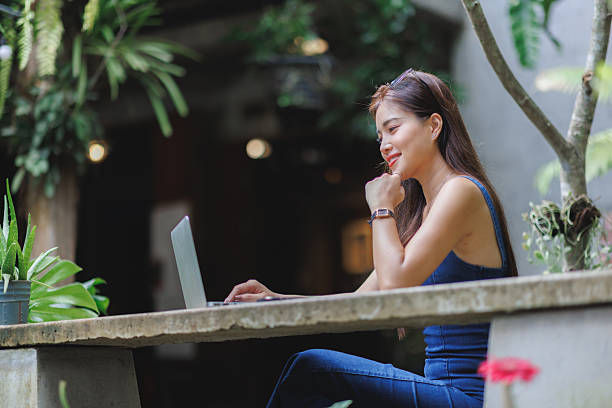 istock Young woman confidently working on laptop in green environment 2237271067