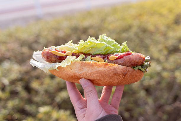 istock A person holding a delicious hot dog 2237271338