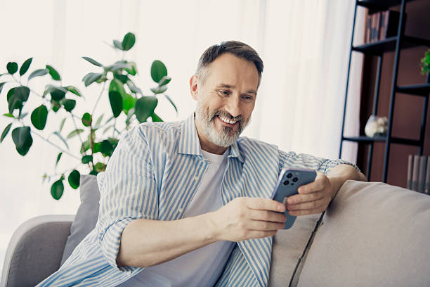 istock Mature man enjoying relaxed time at home using a smartphone indoors 2237271754