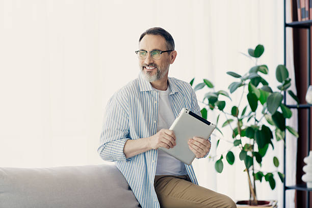 istock Confident mature man working on his tablet at home, embracing a successful and relaxed lifestyle 2237271805