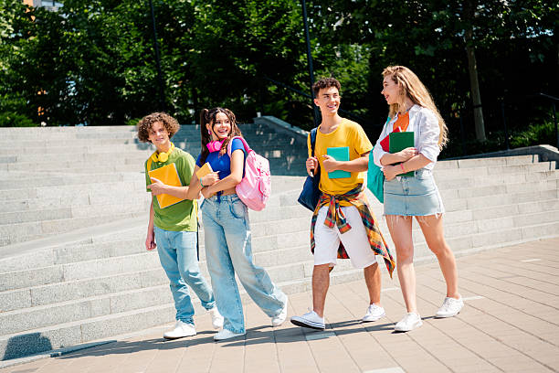 istock Group of diverse students enjoying day outdoors, bonding and carrying book 2237271942