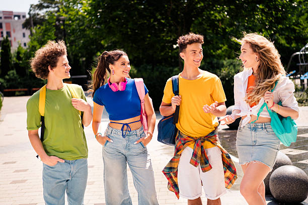 istock A group of young friends walking together outdoors during summer, engaging in conversation, wearing casual outfits 2237272001