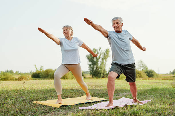 istock Active senior couple doing the warrior pose in a field, showing a healthy and peaceful retirement. 2237277002