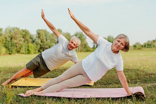 istock An elderly couple enjoys a peaceful moment while practicing yoga on colorful mats in a sunlit park. They share smiles and balance as they stretch 2237277024