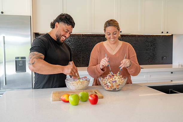 istock Smiling Couple Preparing Salad in Modern Kitchen 2237279288