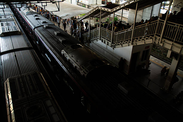 image of passengers arriving with a commuter train at a busy station platform. The image showcases people stepping out of the train, carrying bags and daily essentials, representing urban mobility, public transportation, and daily commuting life. Perfect for illustrating city lifestyle, modern infrastructure, and efficient mass transit systems in metropolitan areas.
