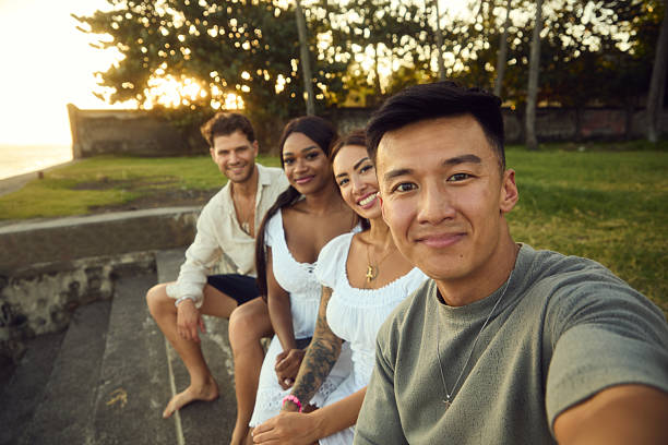 istock Four friends take a sunny group selfie at sunset on a beachside park, smiling and enjoying a vacation moment 2237280865
