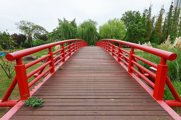 Red steel structure arched bridge in the public park