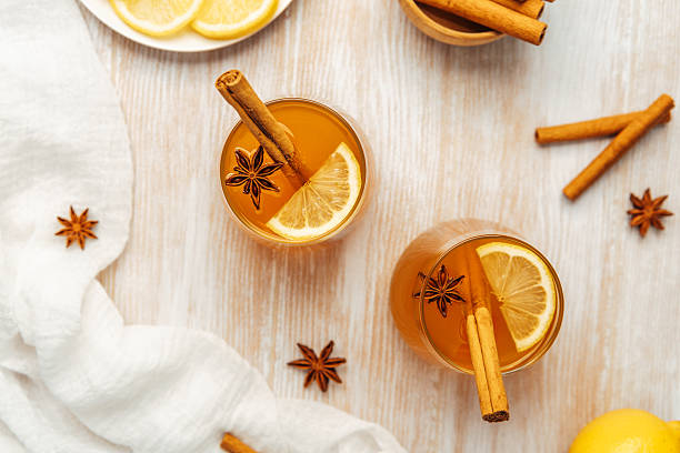 istock Two spiced drinks with lemon, cinnamon sticks, and star anise on a rustic wooden table 2237285811