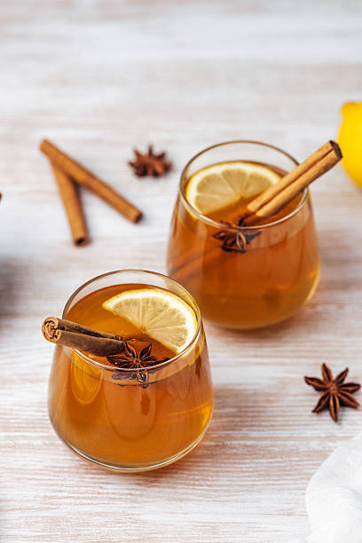 istock Warm cider with cinnamon sticks, lemon slices, and star anise on a wooden table 2237285821