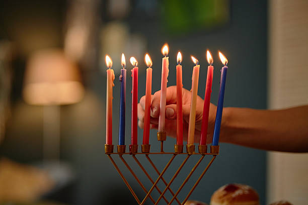 istock Hand Lighting Candles on Menorah Celebrating Hanukkah Holiday 2237286654