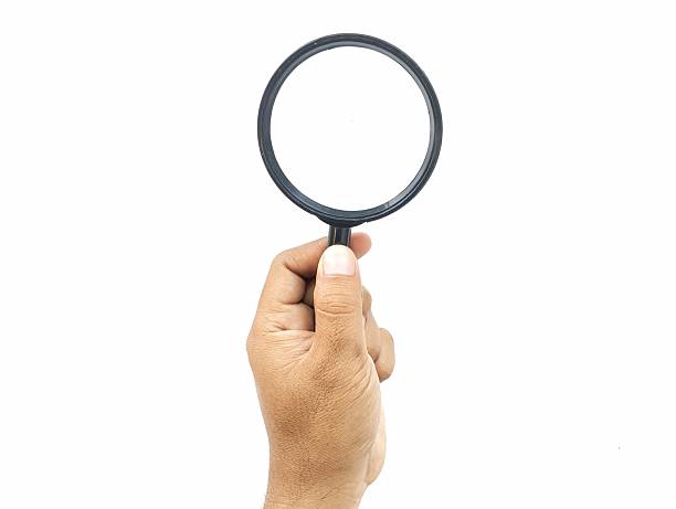 istock Man hand holding a magnifying glass isolated on white background 2237287243