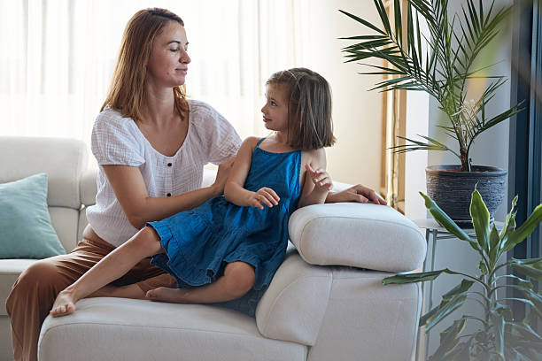 istock Mother and daughter talking on sofa at home 2237288718